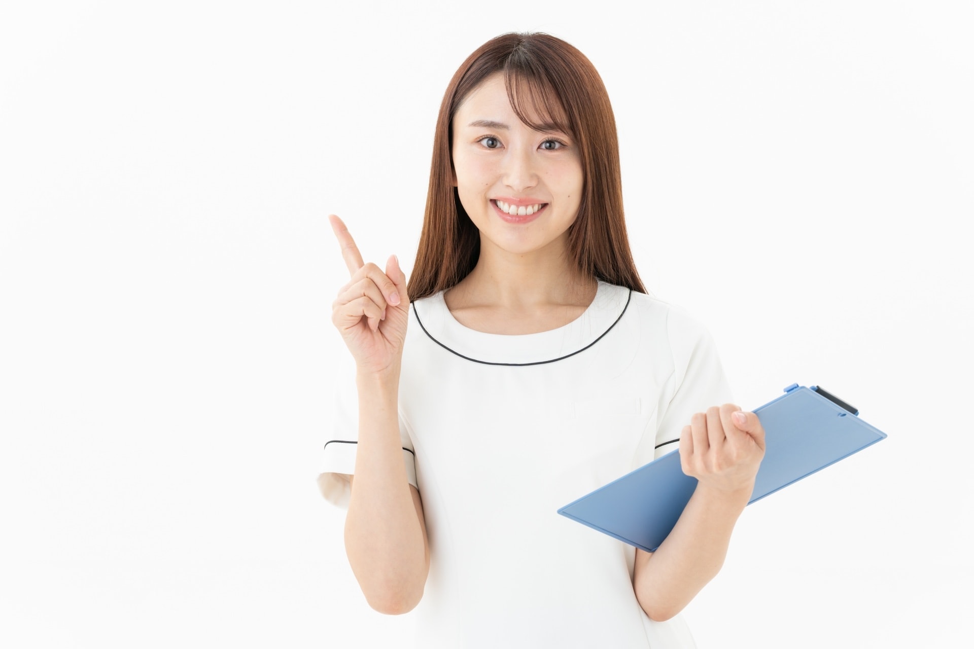 笑顔で予約カレンダーを指さすサロンスタッフの女性