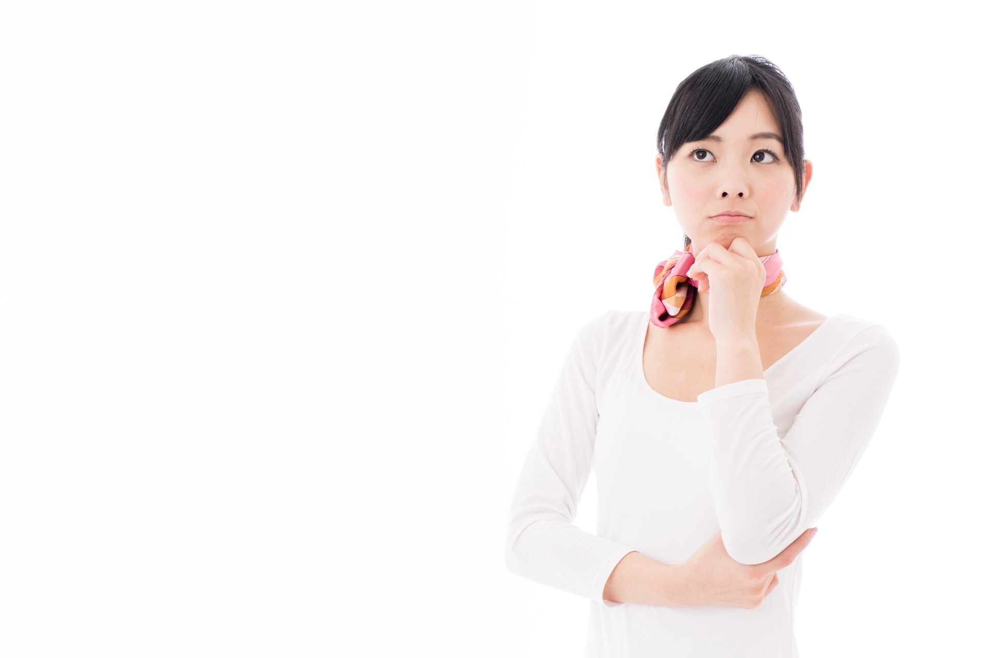 悩みごとを考えながら上を見つめるサロンスタッフの女性
